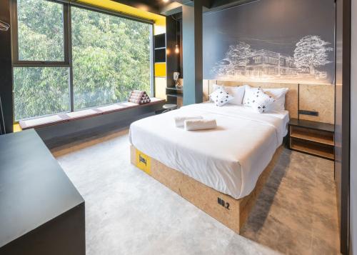 a bedroom with a large bed and a large window at LOBSUEK Hostel หลบศึก โฮสเทล in Bangkok