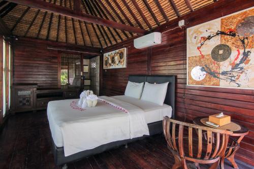 1 dormitorio con 1 cama y 1 silla en una habitación en Bellewood Villa by Sadev Resort, en Gili Trawangan