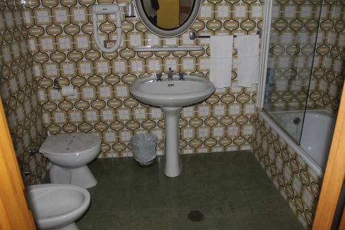 a bathroom with a sink and a toilet and a mirror at Hotel Ismaele in Chiusi