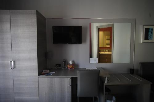 a room with a desk with a mirror and a table at La Dimora in Catania