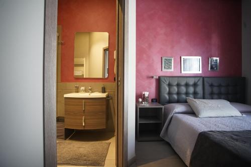a bedroom with a bed and a sink and a mirror at La Dimora in Catania