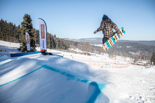 a person doing a trick on a snowboard in the air at Apartmán Riviéra Lipno 510/21 in Lipno nad Vltavou