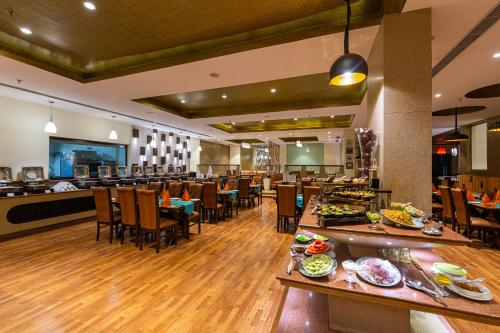 a restaurant with tables and chairs and a buffet at Ramada Neemrana in Neemrana