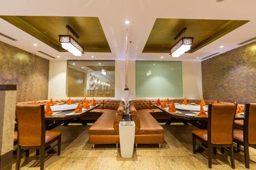 a dining room with tables and chairs and a large screen at Ramada Neemrana in Neemrana