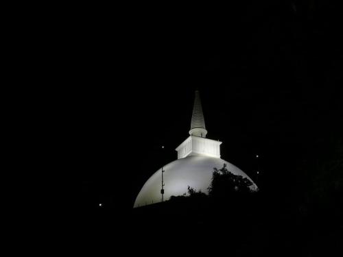 a white steeple of a building at night at Green Cottage in Anuradhapura