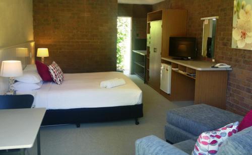 um quarto de hotel com uma cama e uma televisão em Motel Sierra - Bright em Bright
