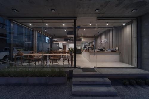 a restaurant with a table and chairs in a building at Mix cafe x Bed D in Mae Sot