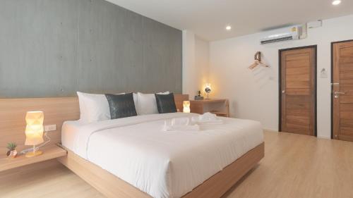 a bedroom with a large white bed with two lamps at Mix cafe x Bed D in Mae Sot