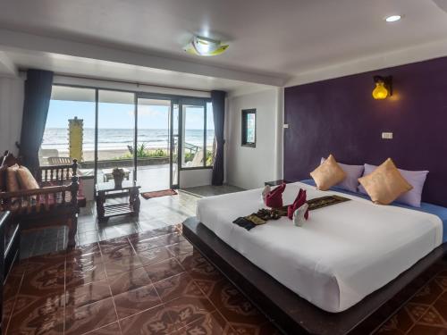 a bedroom with a large bed with a view of the ocean at Lanta Garden Home in Ko Lanta