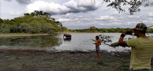 a man taking a picture of a woman and an elephant in the water at Green Cottage in Anuradhapura