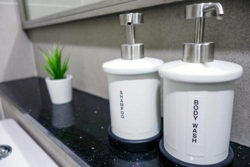 zwei weiße Flaschen auf einer Theke im Bad in der Unterkunft Tropicana 218 MACALISTER in George Town