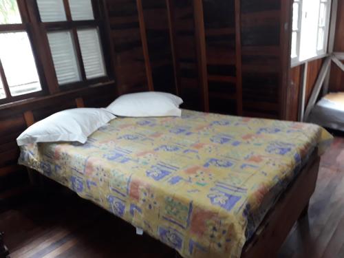 uma cama num quarto com janelas em residencial Remanso em Florianópolis