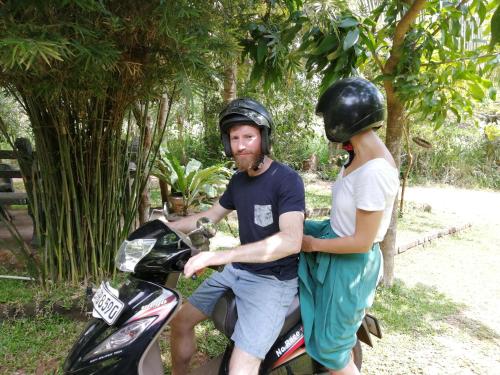 a man and a woman on a motorcycle with helmets on at Green Cottage in Anuradhapura