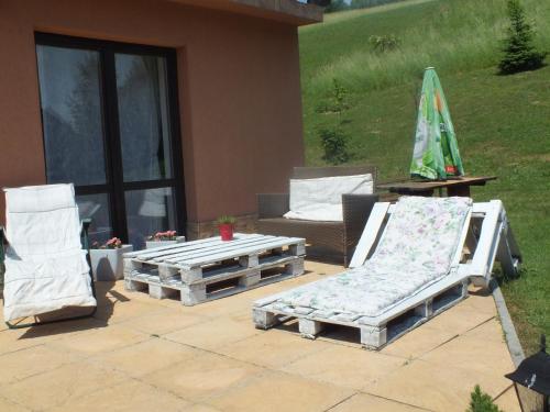 two lounge chairs and a coffee table on a patio at Wypoczynek u Gosi in Grywałd