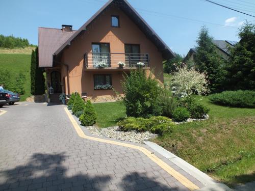 a house with a balcony on the side of a driveway at Wypoczynek u Gosi in Grywałd