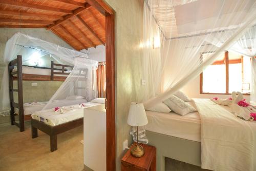 a bedroom with two beds with mosquito nets at De Silva Palm Resort in Kalpitiya
