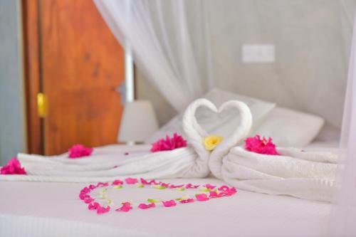 a bed with towels in the shape of a heart at De Silva Palm Resort in Kalpitiya