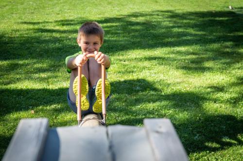 a young boy is holding a baseball bat at Hotel Gardenazza in Badia