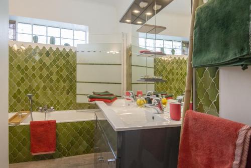 une salle de bain avec un lavabo, une baignoire et un miroir dans l'établissement Mas Roseland, à Saint-Paul-de-Vence