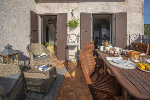 une table et des chaises en bois sur une terrasse dans l'établissement Mas Roseland, à Saint-Paul-de-Vence