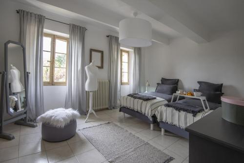 une chambre avec un lit, une table et un miroir dans l'établissement Mas Roseland, à Saint-Paul-de-Vence