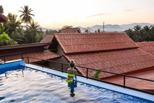 a woman in a swimming pool at a resort at Mad Monkey Luang Prabang in Luang Prabang