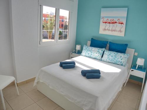1 dormitorio con 1 cama con 2 almohadas en FeWo Flamingo - Morro Jable Fuerteventura, en Morro del Jable