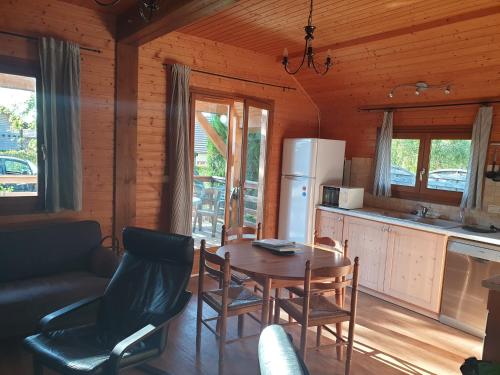 a kitchen and dining room with a table and chairs at Chalets les Silènes in Doucier
