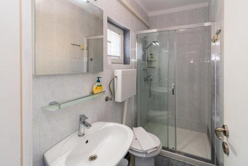 a bathroom with a sink and a shower and a toilet at Apartments Irena Krk in Krk