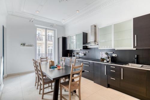 une cuisine avec une table et des chaises dans une pièce dans l'établissement Sweett - Rue de Cerisoles, à Paris