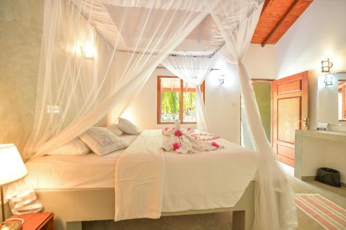 a bedroom with a bed with mosquito netting at De Silva Palm Resort in Kalpitiya