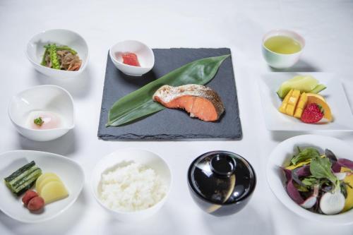a white table with plates of food and bowls of food at Hotel Marroad Karuizawa in Karuizawa