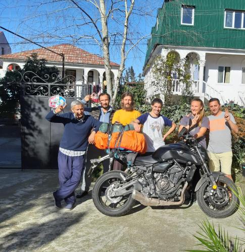 a group of people standing next to a motorcycle at Merabi Guest House in Makhinjauri