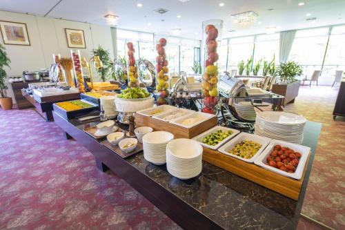 a buffet line with plates and food on a table at Hotel Marroad Karuizawa in Karuizawa