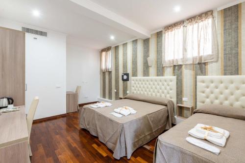 pokój z 2 łóżkami i stołem z ręcznikami w obiekcie chèri luxury suite w Rzymie