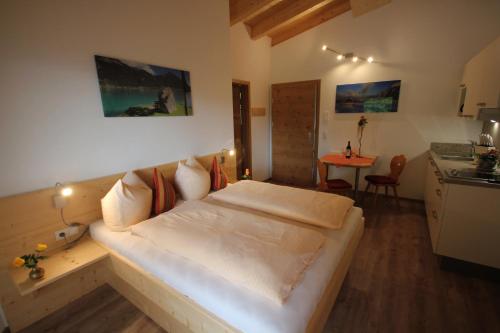 a bedroom with a white bed and a table at Ferienwohnungen Karwendel Camping in Maurach