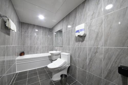 a bathroom with a toilet and a bath tub at Eco Hotel in Mokpo