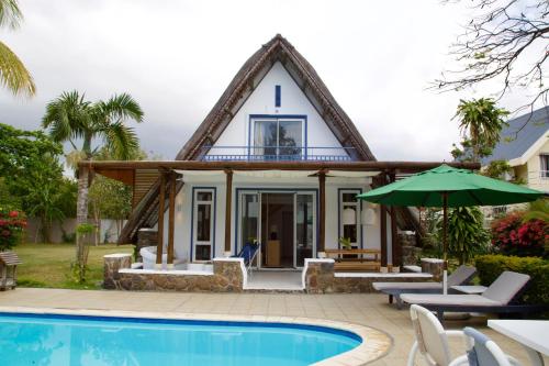 a house with a pool in front of it at Blue Bird in Pereybere