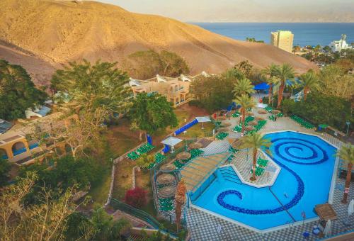 Club In Eilat - Coral Beach Villa Resort في إيلات: اطلالة جوية على منتجع مع مسبح