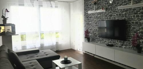 a living room with a couch and a brick wall at BS Business Travelling Hannover City in Hannover