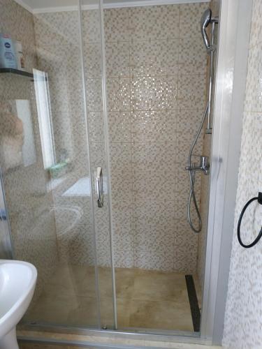 a shower with a glass door in a bathroom at Entire Home in Bucharest