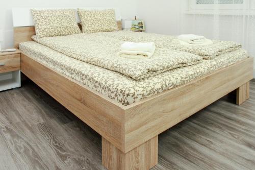 1 cama grande de madera con 2 almohadas en Apartmani Bojana, en Vrdnik