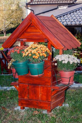 a wooden flower stand with three pots of flowers at Apartmani Bojana in Vrdnik