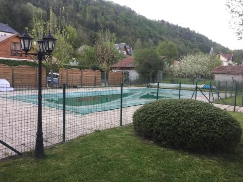 Vaulnaveys-le-HautにあるLe globeの庭のテニスコート付柵