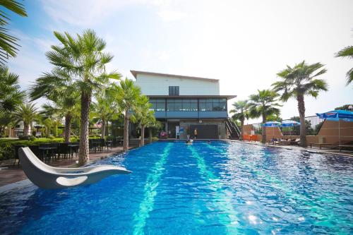 a swimming pool with a slide in front of a building at Jintana Resort in Buriram