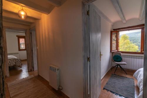 a hallway with a room with a window and a bed at La Borda del Feu in Guardia de Arés