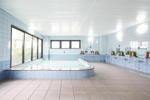 a large bathroom with a swimming pool and toilets at Hotel Station Kyoto West in Kyoto