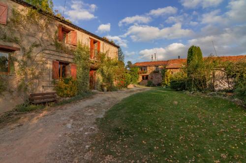 a dirt road next to a building with a bench at La Borda del Feu in Guardia de Arés