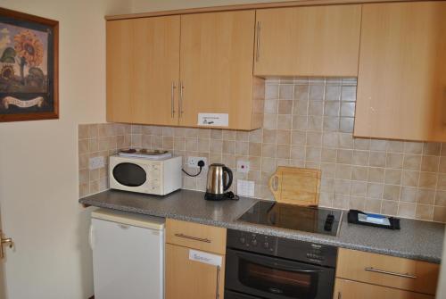 a kitchen with a counter top with a microwave at Oldcotes Cottages in Firbeck