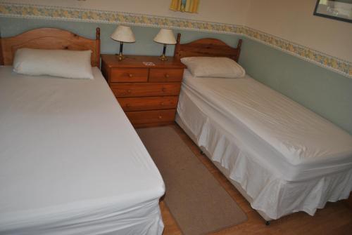 two twin beds in a room with two night stands at Oldcotes Cottages in Firbeck